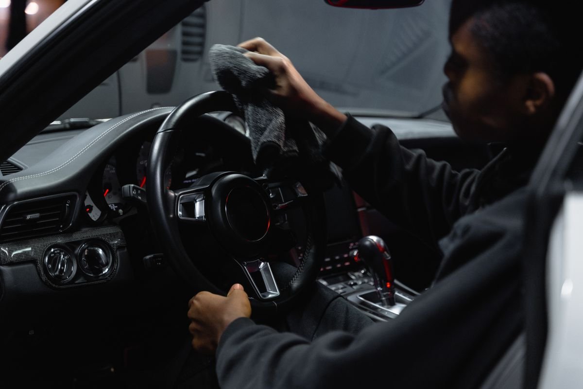 Detailer wiping down a car interior